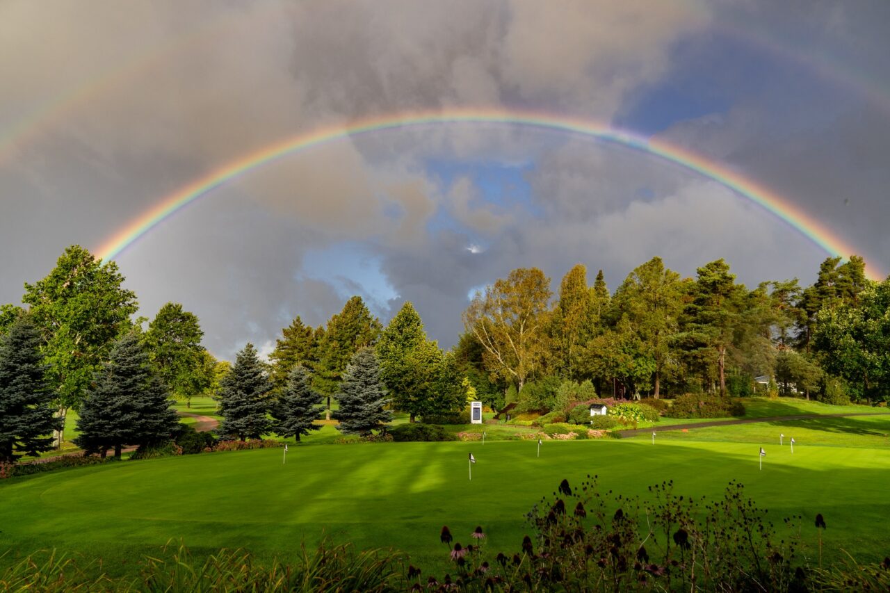 Golf kenttä ja sateenkaari