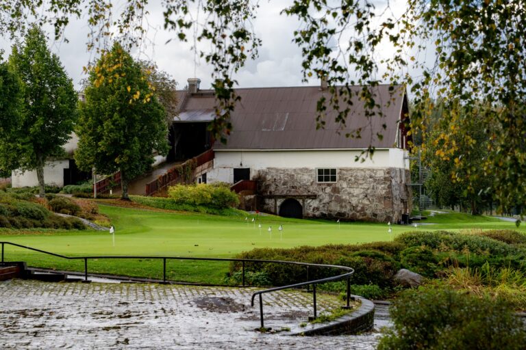 Golfcourse landscape with water and barn